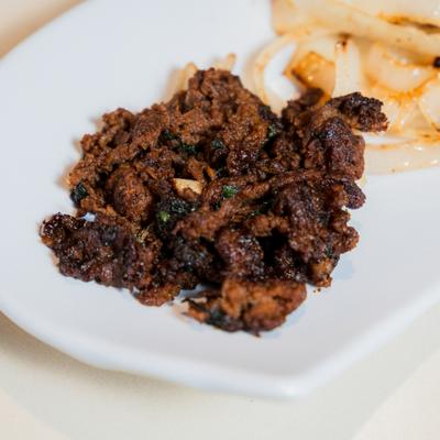 Beef bulgogi served on a white plate with grilled onions.