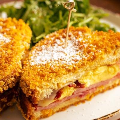 Monte Cristo sandwich served with arugula salad, close up.