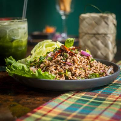 Thai minced meat salad with herbs, cabbage, and an iced green drink.