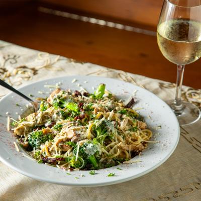 Chicken Artichoke Pasta paired with a glass of white wine.