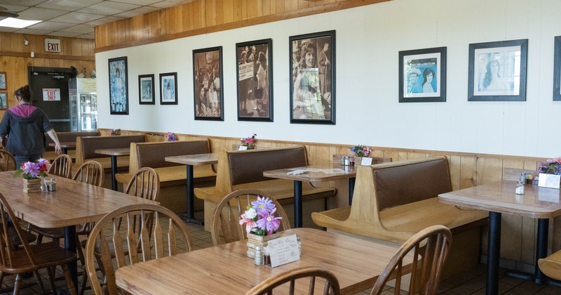 Interior of a casual dining restaurant with wooden tables, vintage photos on the walls