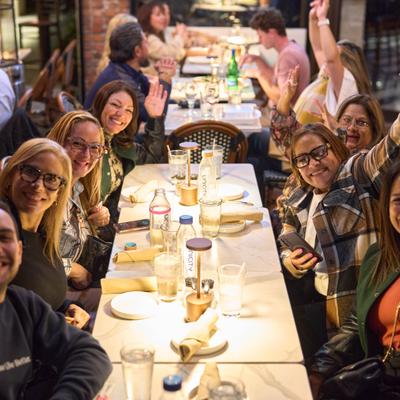 A group of people enjoying a meal together at a long restaurant table.