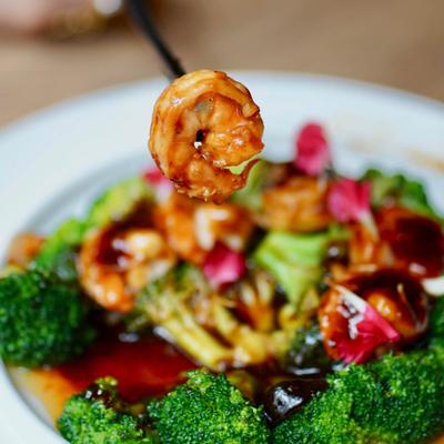 Close-up of shrimp with broccoli and sauce.