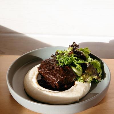 Braised beef short rib over creamy puree with fresh salad greens.