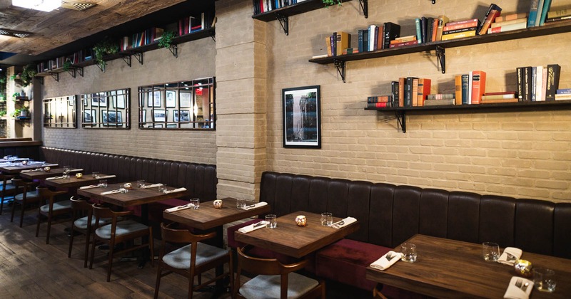 Interior, tables, chairs, booths, books on shelves, decorative mirrors