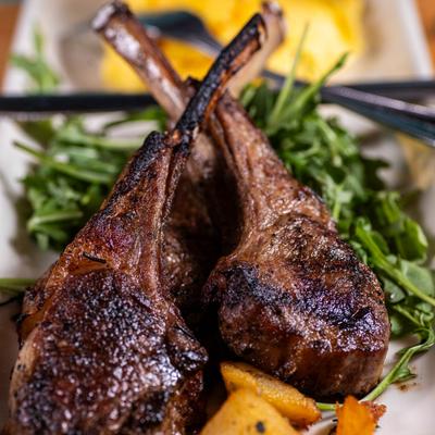 Two grilled lamb chops on greens.