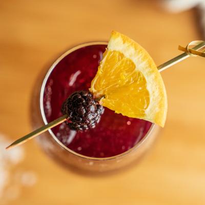 Red Sangria with blackberry and orange garnish.