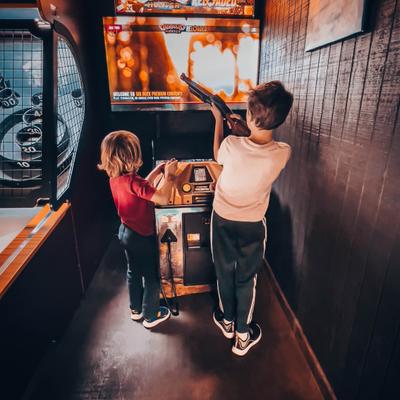 Kids playing an arcade shooting game.