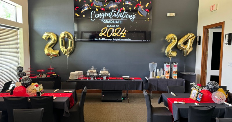 Graduation party setup with a buffet table, balloons, and decorations