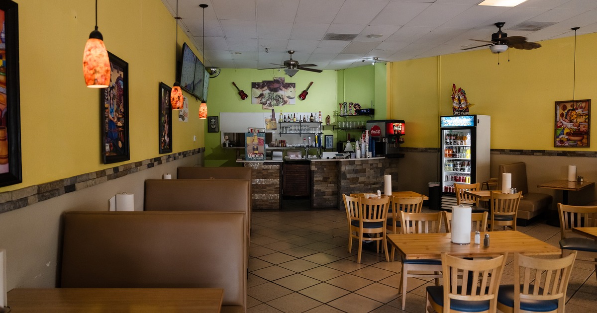 Cozy interior dining area and order counter, tables, chairs, and upholstered booths along the wall