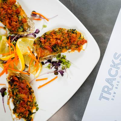 Oysters topped with herbs, breadcrumbs, and creamed spinach.