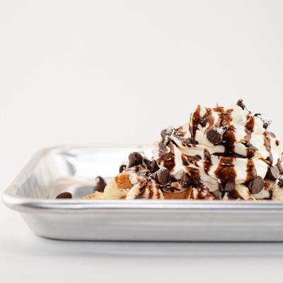 Waffles topped with chocolate and whipped cream.