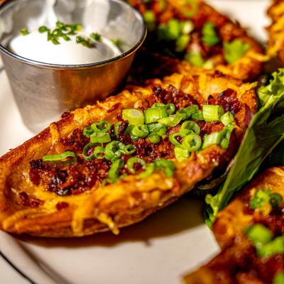 Loaded potato skins, with bacon, cheese, and scallions.