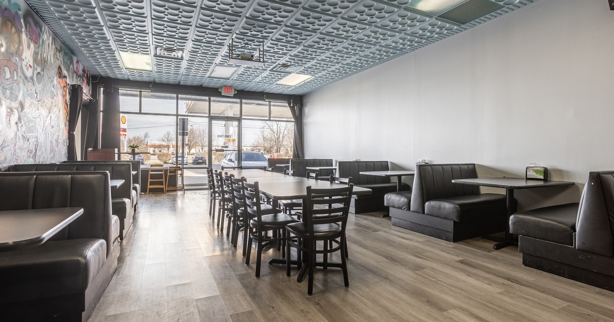 Specious seating area with a long table at the center and booths along the walls on both sides