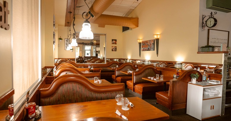 Interior, warmly lit dining area, wooden benches and tables, low hanging lights