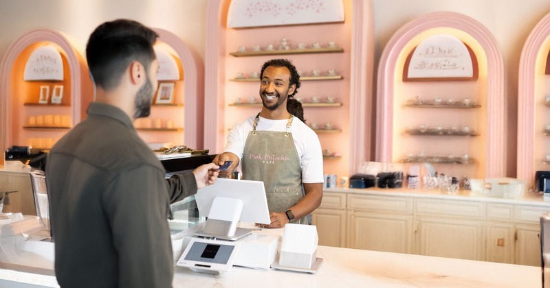 A friendly cashier interacts with a customer