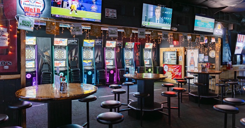 Round tables with conjoined stools, darts on the left