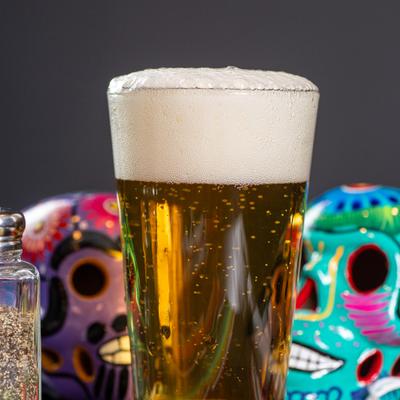 A glass of beer with a thick head of foam.