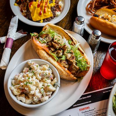 Chicken spiedie sandwich served with a side of macaroni salad.