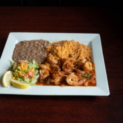 Jumbo shrimp sauteed with special red sauce and served with rice and beans.