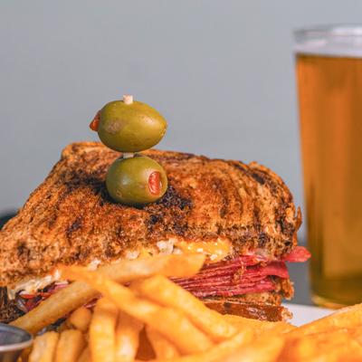 NY Reuben dish served with a glass of beer