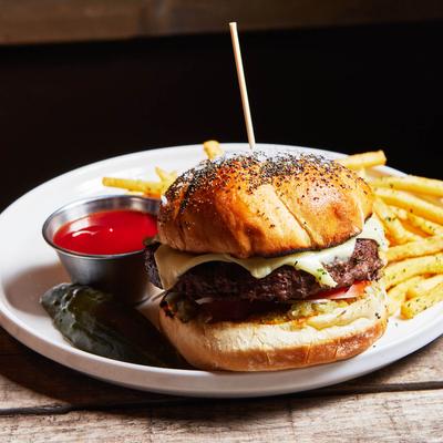 Burger served with a sauce for dipping and fries.