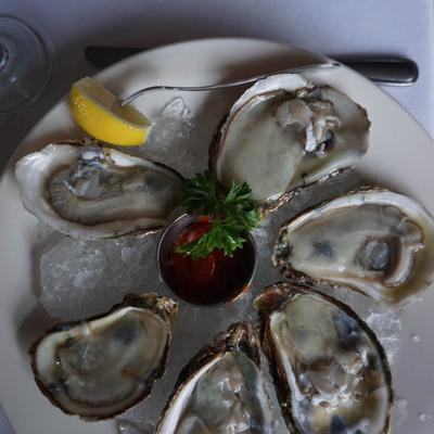 Oysters on ice with parsley and dipping sauce.