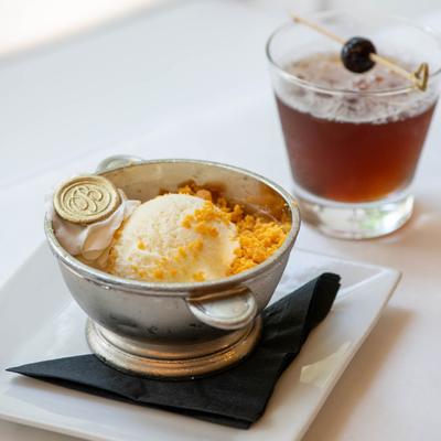 Vanilla Ice Cream, with whipped cream, crumbles, and a cocktail on the side