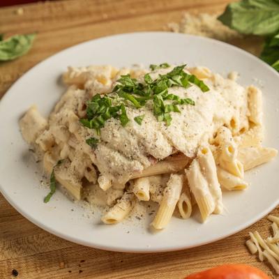 Chicken Alfredo rigatoni pasta topped with herbed Parmesan.