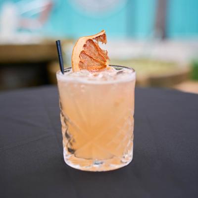 Paloma cocktail garnished with a dry grapefruit slice.