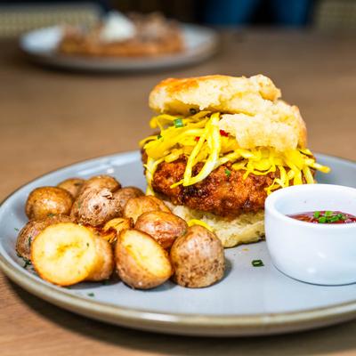 Nashville deluxe sandwich with potatoes and a sauce for dipping.