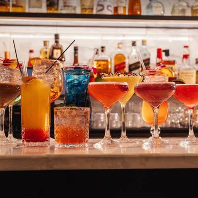 A vibrant display of colorful cocktails on a bar counter.