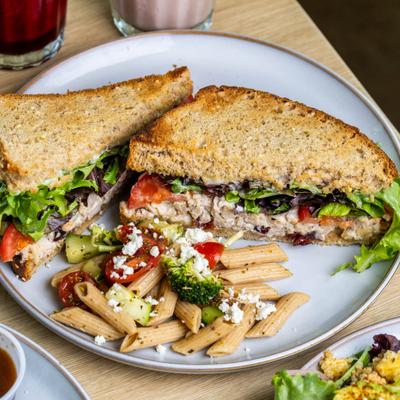 Chicken Salad sandwich with lettuce, tomato, mayo and pasta salad on the side.