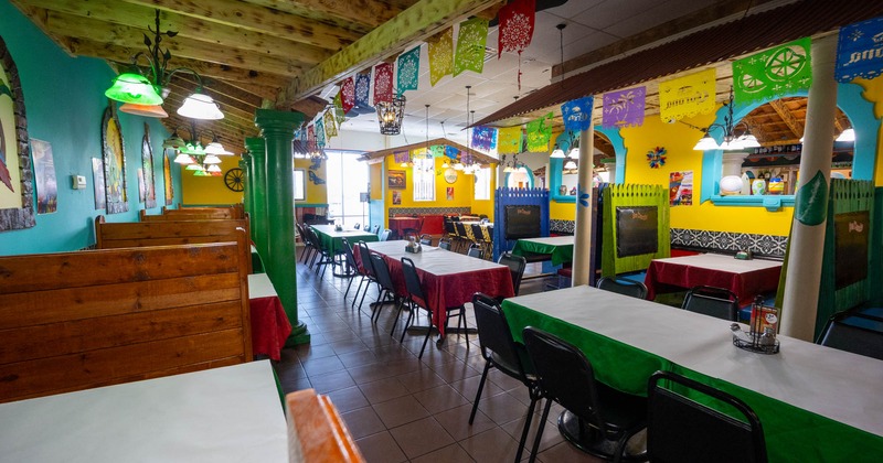 Interior of a colorful restaurant with wooden booths and festive decor