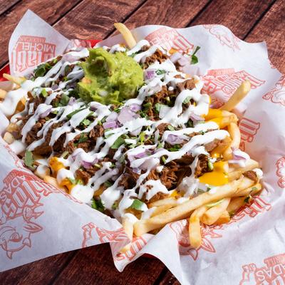 Loaded fries topped with pulled meat, sour cream, and guacamole.