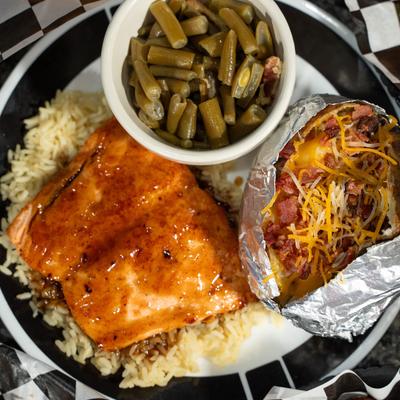Atalantic salmon filet served over rice with loaded baked potato and green beans.
