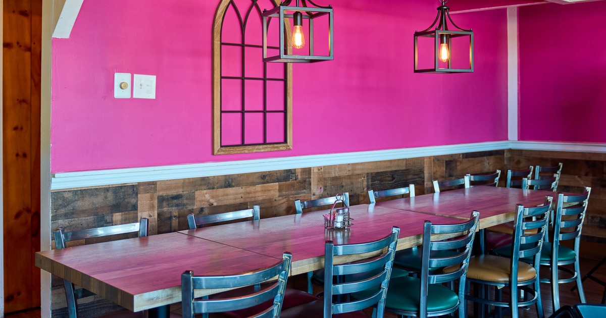 Interior, tables and chairs by the pink wall