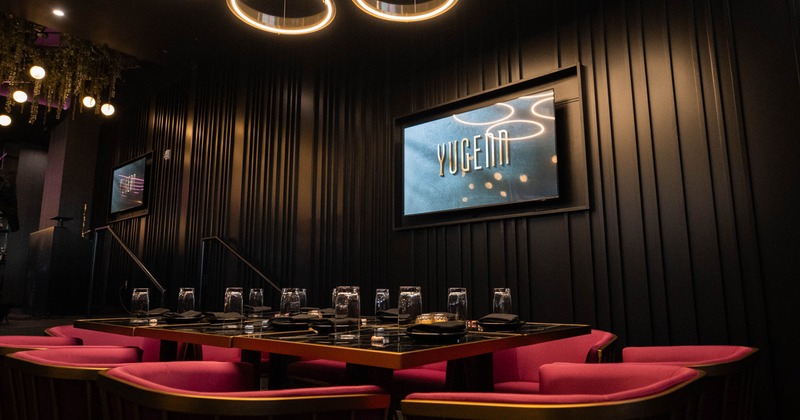 Dining room with modern lighting, set table and a TV screen