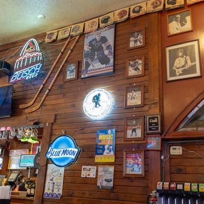 Bar with sports memorabilia and various beer brand signs decorating the wooden walls.