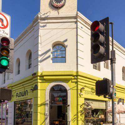 Cafe's building on a street corner, distinguished by bright yellow facade.