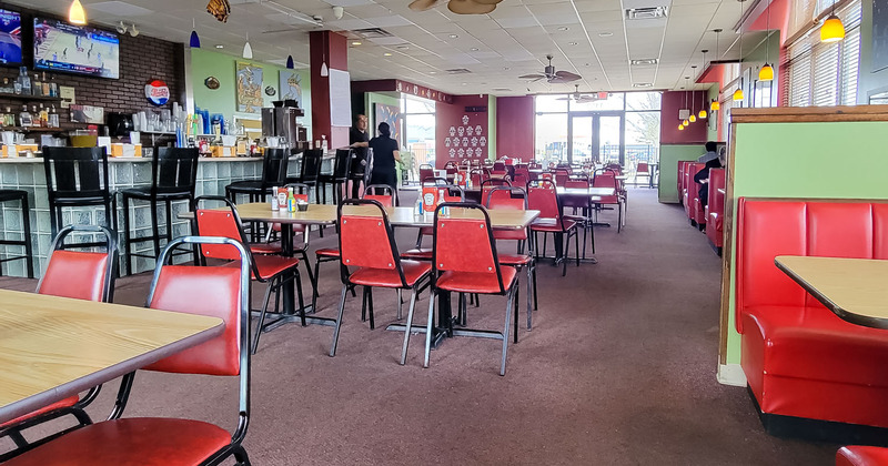 Interior, bar and seating area, staff members working, tables ready for guests