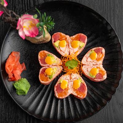 Heart-shaped sushi rolls with salmon and tuna, wrapped in pink soybean paper.