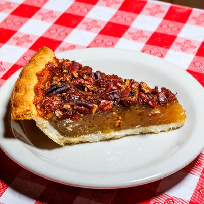 A slice of pecan pie on a white plate.