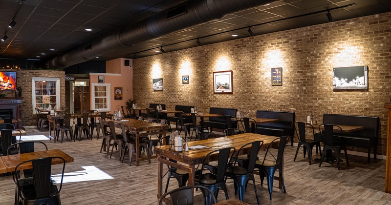 Warm and cozy interior with wooden tables, metal chairs and upholstered bench seating along the wall