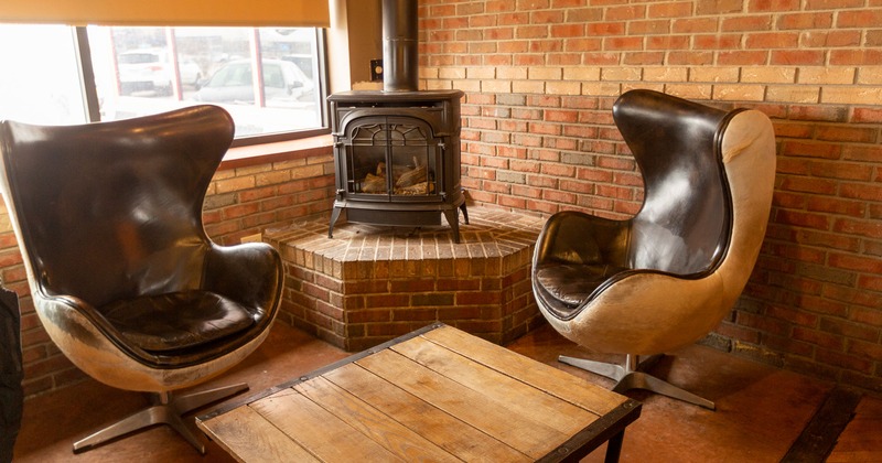 Interior, two vintage egg chairs, a stove in the middle