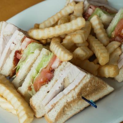 Turkey club sandwich with fries.