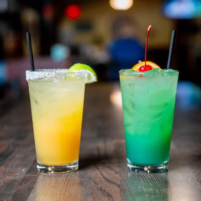 Patron Tiki Rita and Blue Mai Tai cocktails with fruit garnishes.