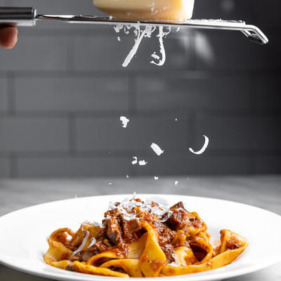 Adding grated cheese to Ragu Pappardelle