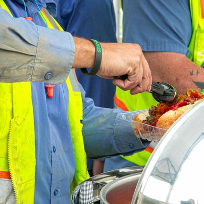 People helping themselves to food from chafing dishes.