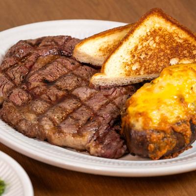 Grilled ribeye, with a baked potato, and toast.